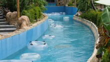 Floats Moving With The Current Of The Empty Lazy River In A Water Park.
