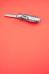 Poster - Vertical isolated shot of the multifunctional pocket knives on a pink background