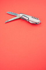 Poster - Vertical isolated shot of the multifunctional pocket knives on a pink background