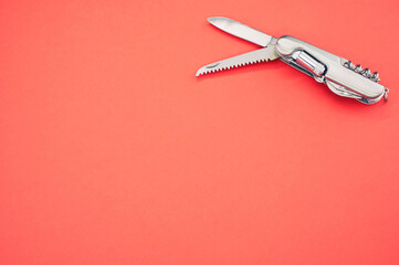 Poster - Isolated shot of the multifunctional pocket knives on a pink background