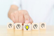 Concept creative idea and innovation. Hand choose wooden cube block with head human symbol and light bulb icon