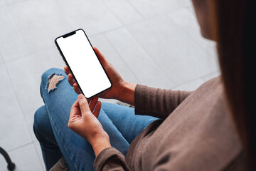 mockup image of a woman holding mobile phone with blank white desktop screen
