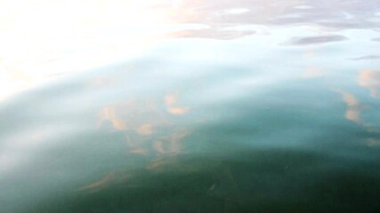 Wall Mural - ripples and glare on the river in the countryside at sunset. reflection of the sky in the water.autu
