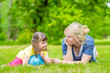 © Ermolaev Alexandr - Mother talks with little girl with syndrome down in a summer park