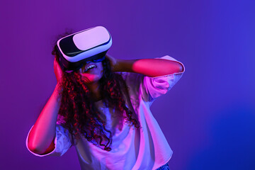 Wall Mural - Young woman with virtual reality glasses on dark color background