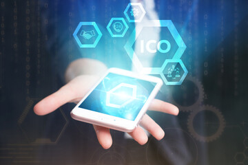 Business, Technology, Internet and network concept. Young businessman working on a virtual screen of the future and sees the inscription: ICO