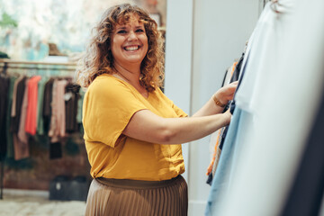 Wall Mural - Woman enjoying shopping in clothing store