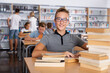 © JackF - Schoolboy sitting with stacks of books in school library indoor