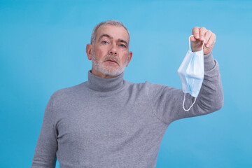 Wall Mural - adult man holding disposable medical mask in hand in virus and infection prevention