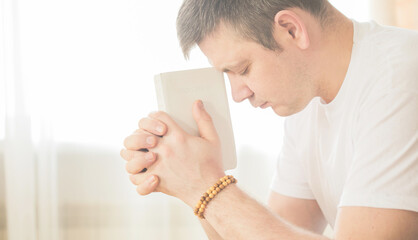 Wall Mural - The Christian holds the Bible in his hands. The concept of faith, spirituality and religion. Prayer for prayer