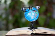 Open The Globe With Glasses On The Book