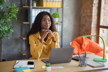 Sticker - Photo of dreamy afro american young businesswoman look away work laptop desk indoors in office workplace