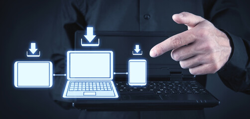 Wall Mural - human hand pointing smartphone, laptop, tablet. download concept