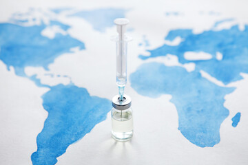 bottle of coronavirus vaccine and syringe on world map background. science laboratory research, vacc