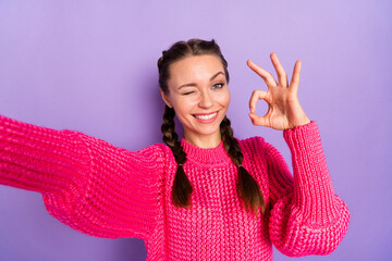 Photo of young beautiful smiling cheerful positive girl take selfie wink eye showing ok sign isolated on purple color background