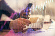 © peshkova - Double exposure of man's hands holding and using a phone and financial graph drawing. Analysis concept.