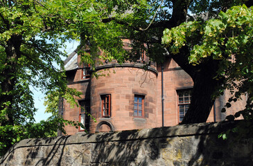 Wall Mural - Old House with Round Tower seen over Stone Wall with Trees 