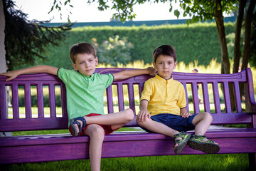 Wall Mural - Group of happy children playing outdoors. Kids having fun in park during summer vacation. Friends walking in sunglasses and smiling. Summer holiday concept