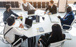 © xartproduction - Group of young business people working and communicating while sitting at the office desk together with colleagues sitting. business meeting. Desktop top view.