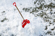 View of a red shovel in snow and red sledge in winter