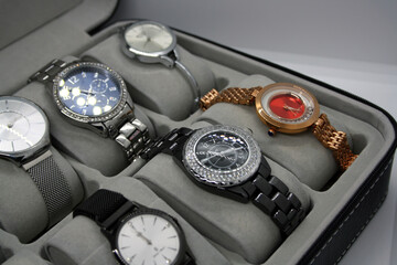 A variety of women's watches in a storage box.