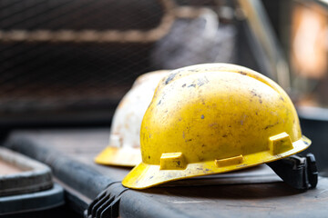 Wall Mural - Dirty safety hardhat which is used in the oil field or drilling operation, it's got dirty from crude oil and waste mud. Close-up and selective focus, heavy industrial object photo.  