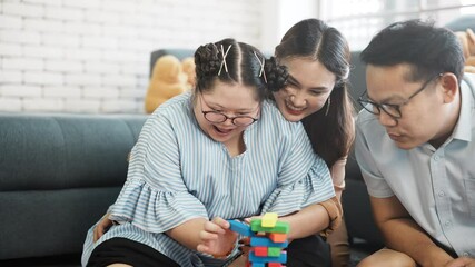 Wall Mural - Happy Down syndrome girl doing activity happily with parent. happy family father and mother take care adopted daughter down syndrome girl spend time together family doing activity together with smile.