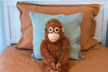 stuffed monkey sitting on a bed