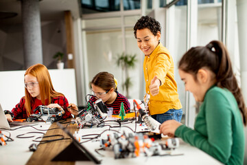 Wall Mural - Happy kids programming electric toys and robots at robotics classroom