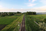 Fototapeta Las - railway track through the village solar power plant