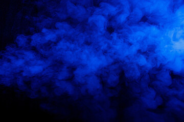 Wall Mural - Abstract blue smoke moves on black background. Beautiful swirling smoke.