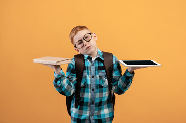 Confused kid schooler holding digital tablet and book