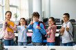 © Prostock-studio - Smiling international schoolchildren showing thumbs up gesture