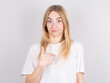© Studio Nova - Pretty young woman feeling confused, puzzled and insecure, pointing to self wondering and asking who, me?