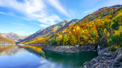 Small waterfall with autumn forest at The Baserca reservoir or Senet reservoir  located on the Noguera Ribagorzana river,Spain