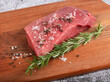 red meat with rosemar and spicery on wood background