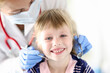 © H_Ko - Portrait of smiling girl at dentist appointment. Treatment of baby milk teeth concept