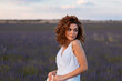 © Cavan Images - woman with curly hair wearing a hat in a lavender field