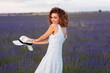 © Cavan Images - woman with curly hair wearing a hat in a lavender field
