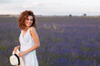 © Cavan Images - woman with curly hair wearing a hat in a lavender field