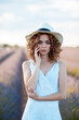 © Cavan Images - curly-haired woman with a hat outdoors