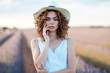 © Cavan Images - woman with curly hair wearing a hat in a lavender field