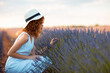 © Cavan Images - woman with curly hair wearing a hat in a lavender field
