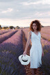 © Cavan Images - woman with curly hair wearing a hat in a lavender field