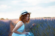 © Cavan Images - woman with curly hair wearing a hat in a lavender field