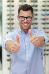 Wall Mural - man with glasses and thumbs up at optics store