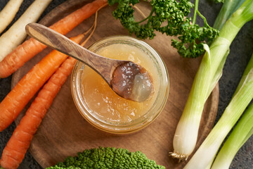 Wall Mural - Cooled down congealed beef bone broth in a glass jar, top view