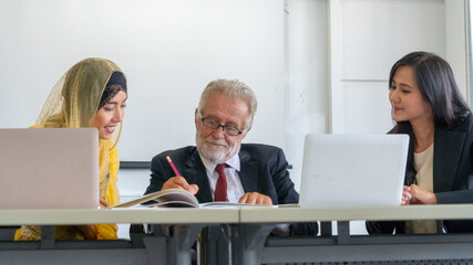 Wall Mural - Senior businessman and young businesswoman partner are happy and talking on around desk office.