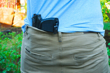 Wall Mural - The gun is hidden behind man's back