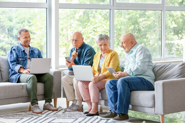 Sticker - Senior people with different devices sitting on sofa at home